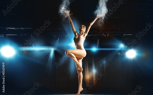 Slim fun caucasian ballerina posing on stage