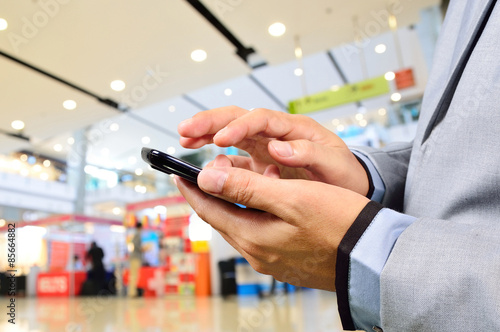 Business Man using Mobile Phone in Modern Shopping Mall
