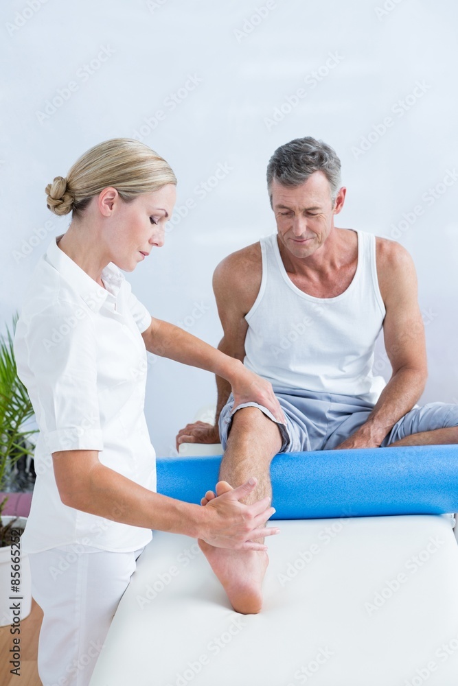 Doctor examining her patient leg 