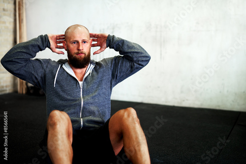 Muscular man concentrating on situps