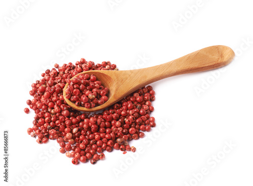 Spoon over the red pepper seeds isolated