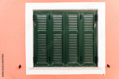 Wooden green window   on pink wall.
