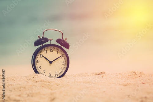 Concept alarm clock on beach of lipe island, thailand. Vintage filter