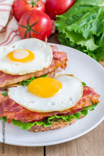 Open face sandwich with egg  bacon  tomato and lettuce