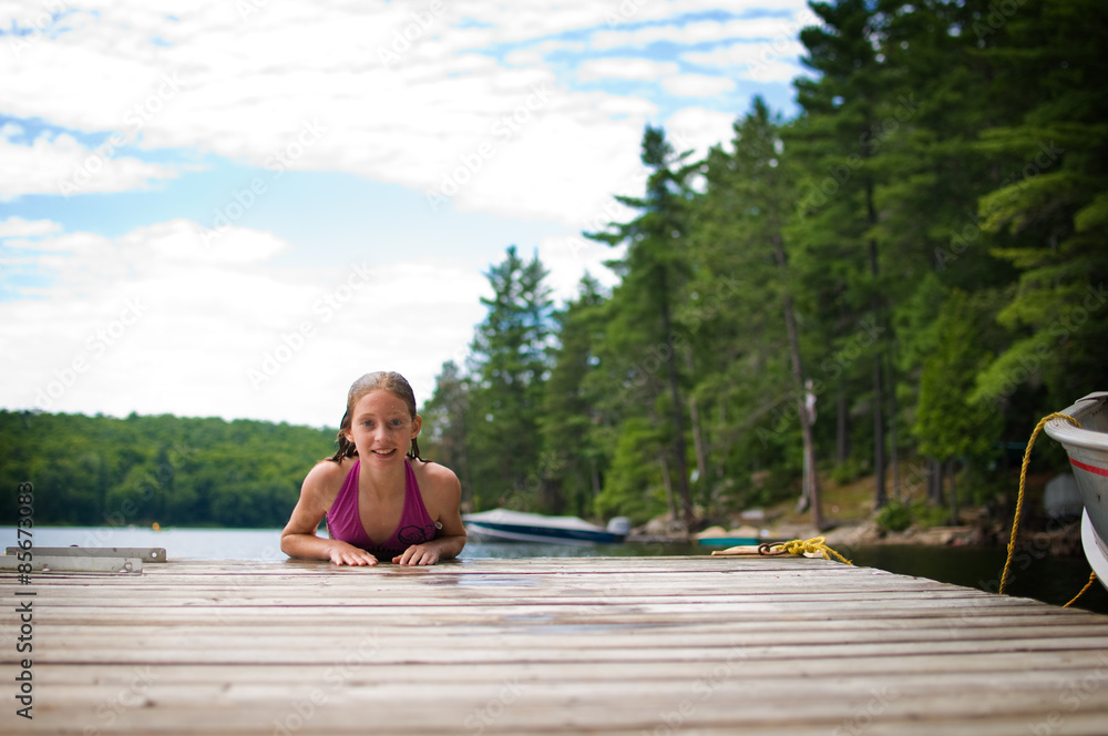 young teenage girl on a dock at a lake in Ontario's cottage country
