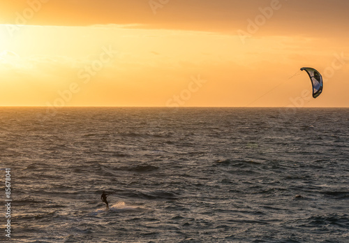 A man kitesurfing during a sunset in Indian ocean in Perth