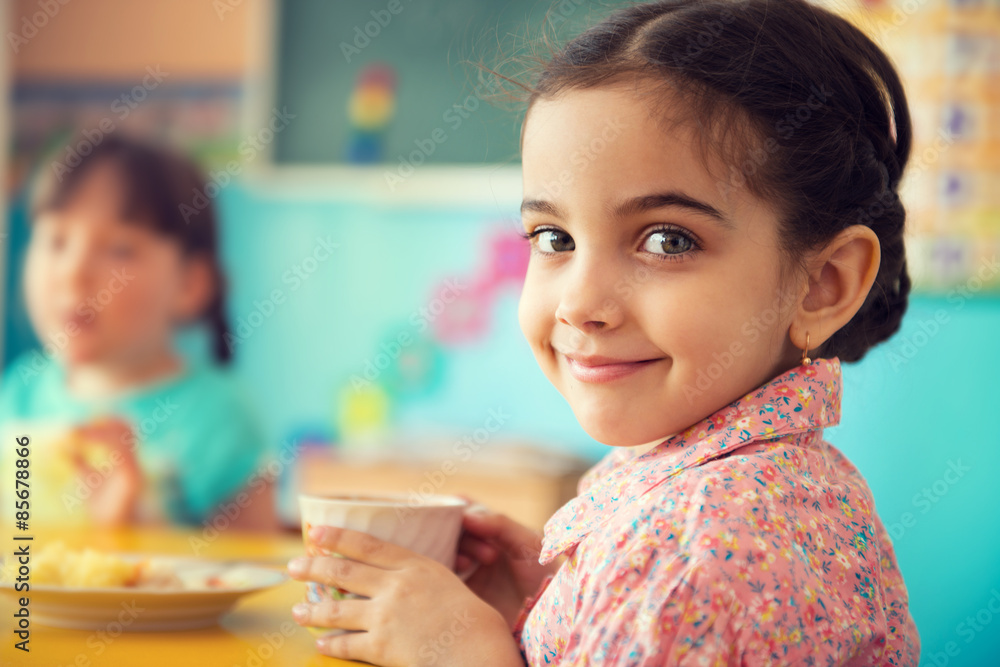 Cute hispanic girl drinking milk at school - obrazy, fototapety, plakaty 