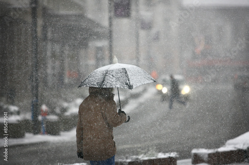 Man with umbrella during snow storm