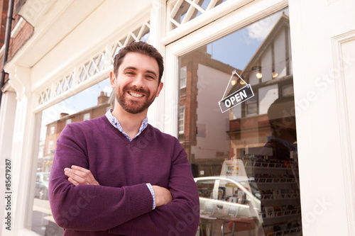 Shop owner standing next to his shop