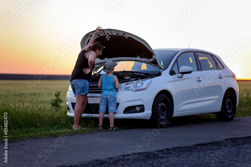 Fényképezés Mother and Son Repairing Something on their Car