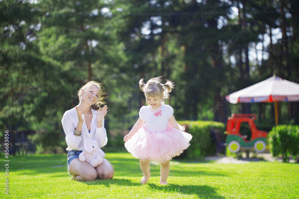 Naklejka premium Smiling girl applauds baby
