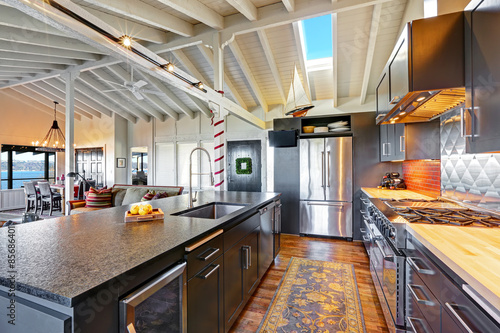 Luxury beautiful dark modern kitchen with vaulted wood ceiling.