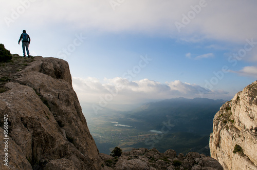 zirve kayalıklardan bölgeyi inceleyen dağcı © emerald_media