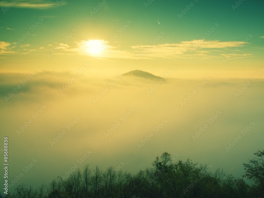 Plakat Magnificent heavy mist in landscape. Autumn fogy sunrise in a countryside. Hill increased from fog.