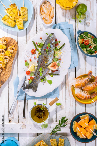 Grilled Fish on Table with Other Dishes