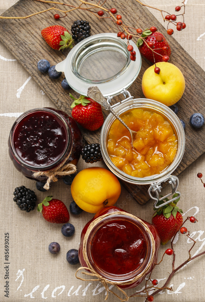 Strawberry, blueberry and peach jams in glass jars Strawberry, blueberry and peach jams in glass jars