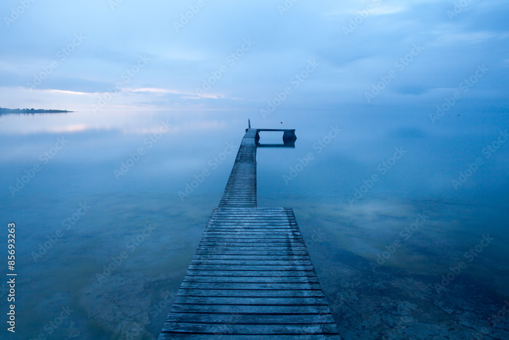 Obraz premium Optical illusion, a bathing jetty seem to float in the air when the sea meets the sky on a magical summer evening at the island of Gotland, Sweden
