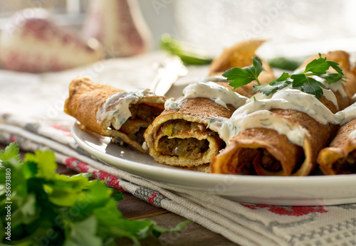 Pancake rolls with mushrooms and yogurt dip