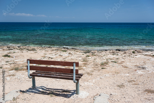 Empty bench at the crystal clear sea