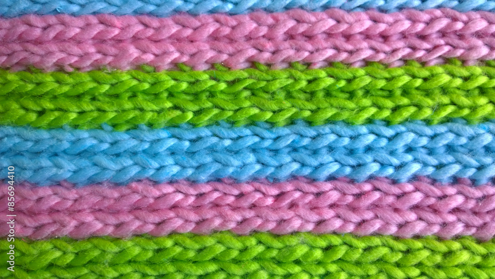 Texture of knitting wool in blue, green and pink colors