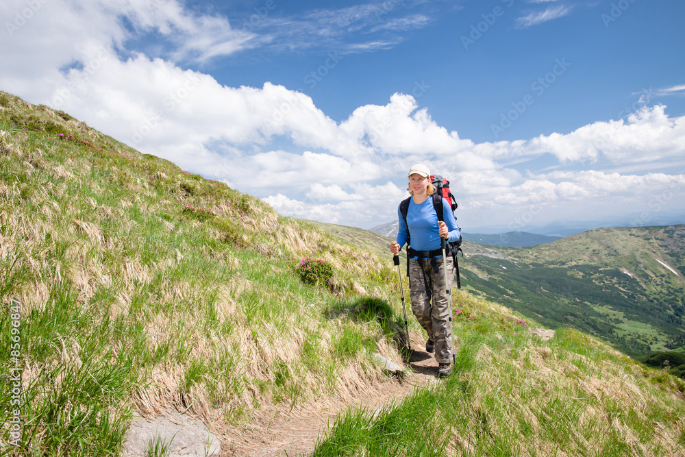 Woman walking on mountain terrain on a sunny day
