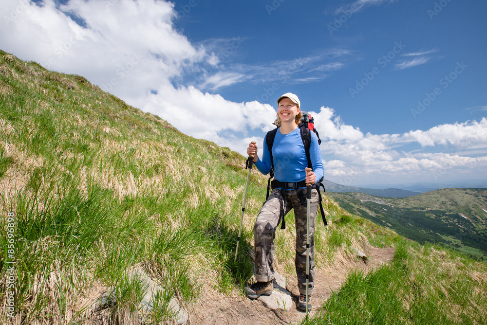 Woman hiking with sticks in Carpathian mountains