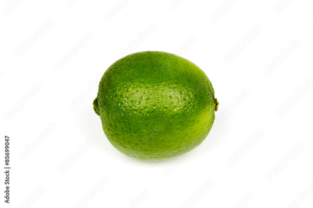 A fresh ripe shiny green lime on a white studio background A fresh ripe shiny green lime on a white studio background