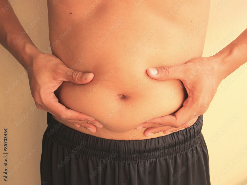 Naklejka premium Man is holding his too fat tummy