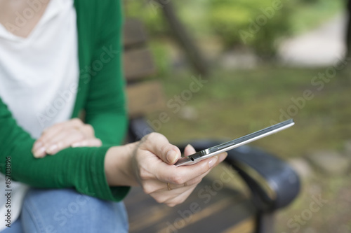 Woman is sitting on a bench in the park