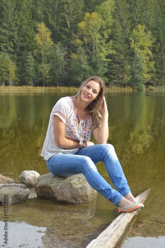 young woman sitting near a lake