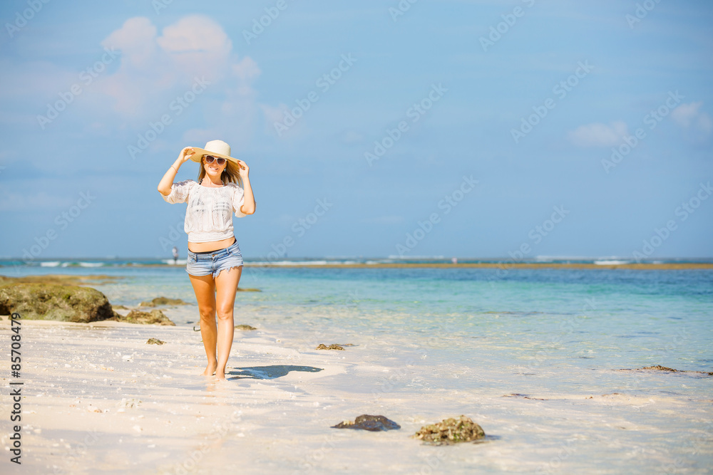Young skinny caucasian girl at the beach with blue sky on Young skinny caucasian girl at the beach with blue sky on