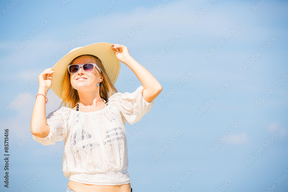Young skinny caucasian girl at the beach with blue sky on