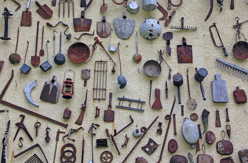 Fototapeta Naklejka Na Ścianę i Meble -  ancient farming tools hanging on the wall of the rural House