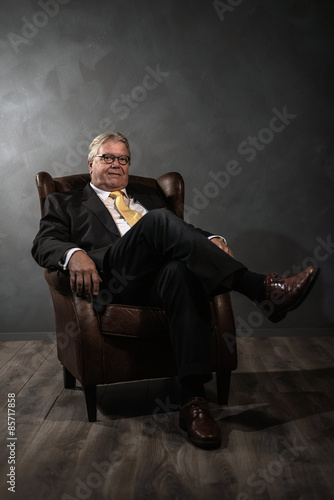 Successful senior man relaxing in an armchair