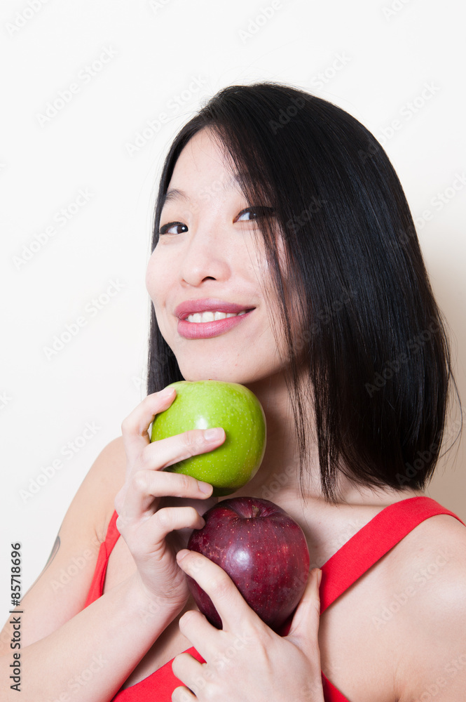 Smiling asian woman with green and red apples on white Smiling asian woman with green and red apples on white