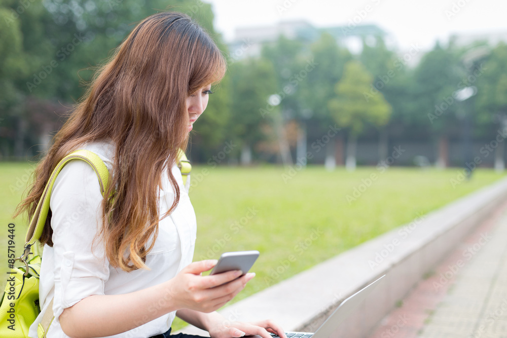 Asian beautiful female studen using mobile phone in campus Asian beautiful female studen using mobile phone in campus