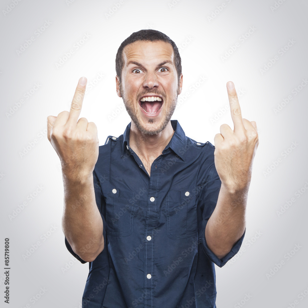 handsome young man showing middle finger, insult sign handsome young man showing middle finger, insult sign
