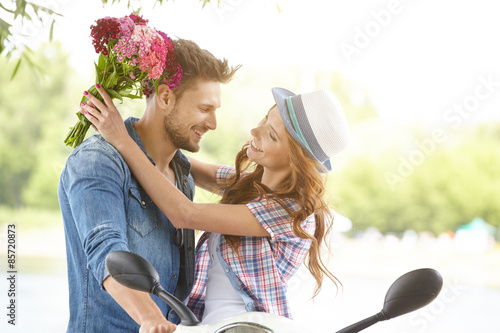 A man gives flowers beautiful woman. In the background the river