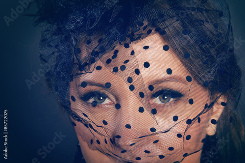 Woman wearing a hat with black veil with dots