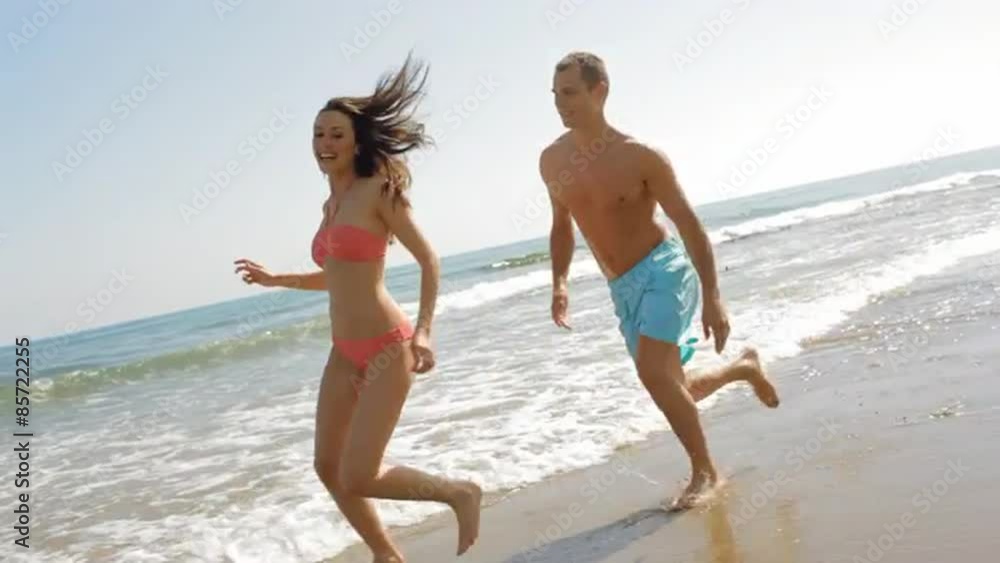 young couple running and chasing on the beach young couple running and chasing on the beach