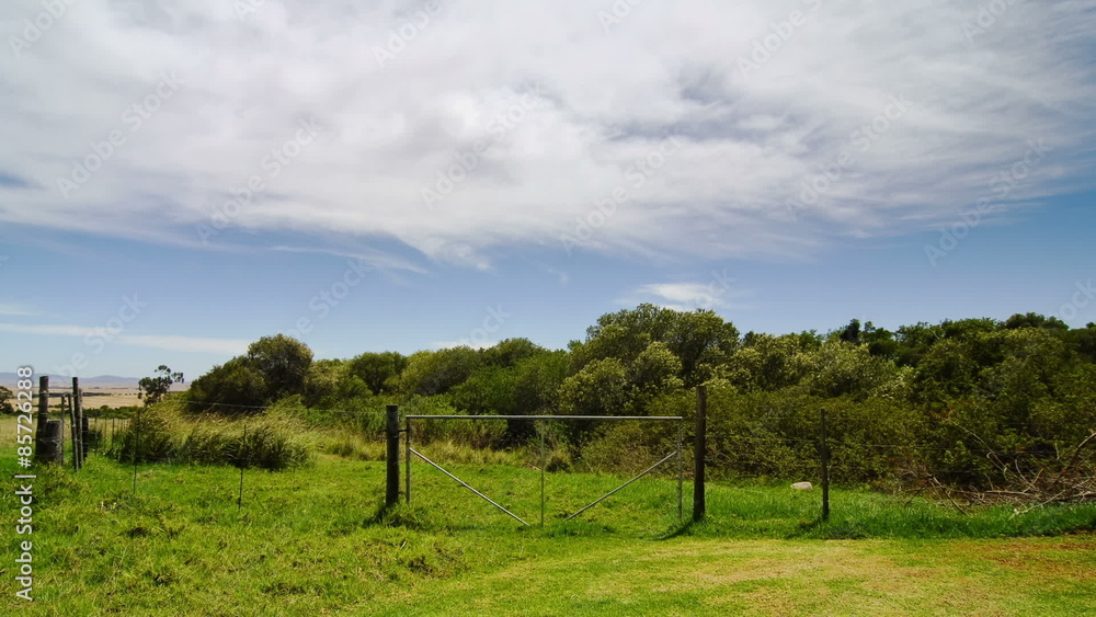 Timelapse of clouds rushing over a gate in an empty field Timelapse of clouds rushing over a gate in an empty field