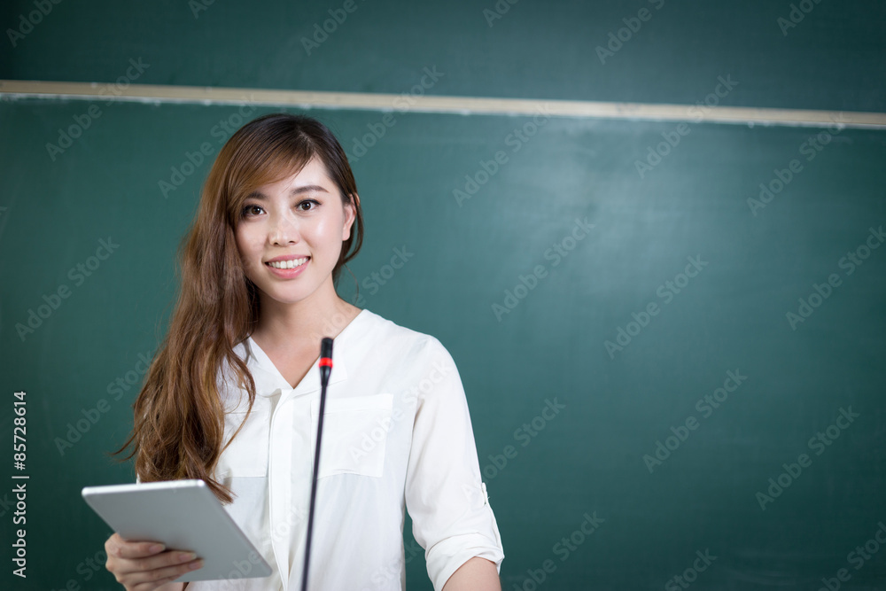 Asian beautiful woman speaking in front of blackboard with micro Asian beautiful woman speaking in front of blackboard with micro