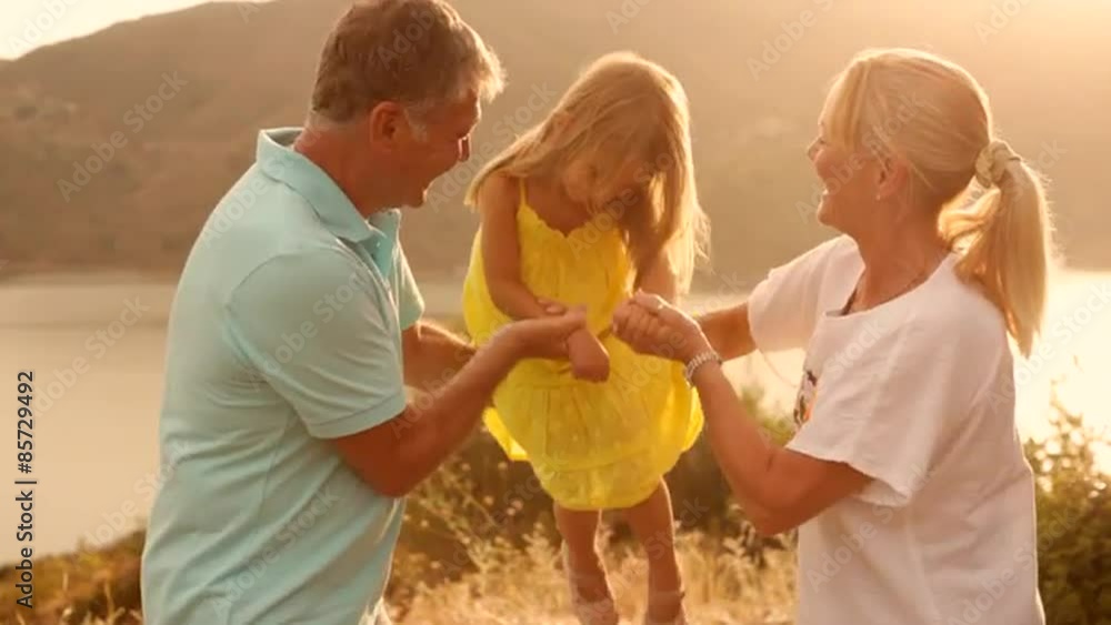 Grandparents and grandchild in sunset in countryside Grandparents and grandchild in sunset in countryside