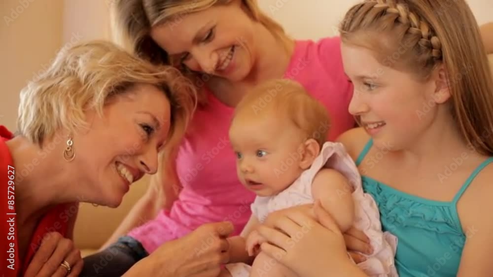 Four generations of females sitting on sofa together. Four generations of females sitting on sofa together.