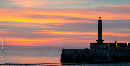 Sunset at Margate, Kent, England, showing part of he harbour wall and the lighthouse photo
