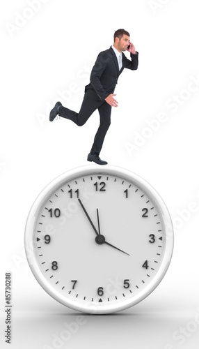 Composite image of businessman running on the phone 