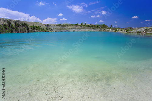 Fototapeta Naklejka Na Ścianę i Meble -  Flooded stone quarry. Crimea. Skalistoe village, Bakhchisaray region. Lake in quarry.