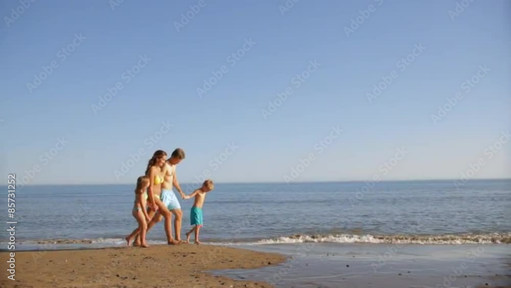 pan shot of family walking on beach