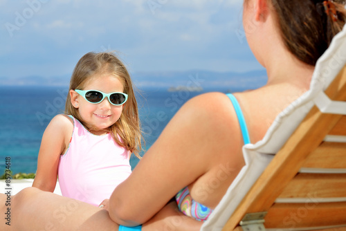 Adorable toddler girl relaxing on sunbed