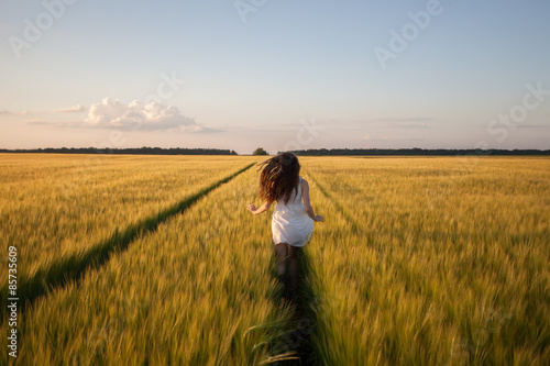 woman run  in yellow wheat field